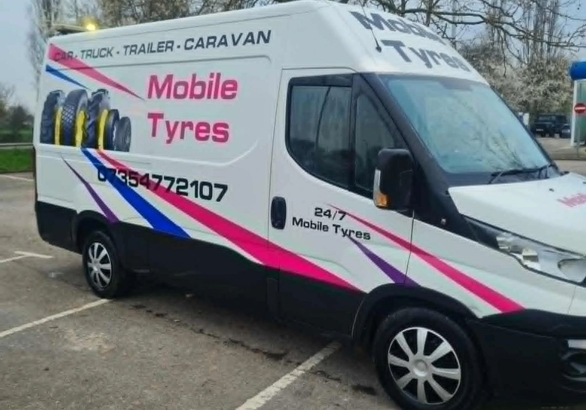 Side view of Craig's van with tyres and the phone number painted on